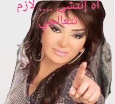 a woman pointing at the camera with an arabic message in front of her and she is smiling