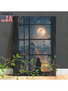 a woman sitting in front of a window looking out at the city and full moon