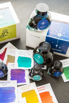 several ink bottles with different colored inks next to each other on top of a table