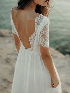 the back of a woman's wedding dress, with lace detailing and open shoulders