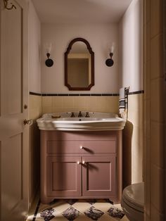 a bathroom with a sink, mirror and toilet in it's doorway way to another room