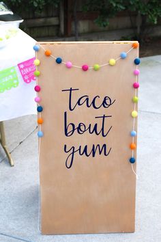 a sign that says taco bout yum on it