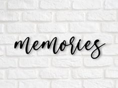 the word memories written in cursive black ink on a white brick wall background