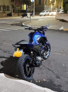 a blue and black motorcycle parked on the street