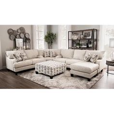 a living room filled with furniture and a large white rug on top of a wooden floor