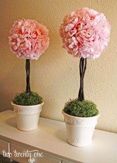 two vases with flowers in them sitting on a shelf