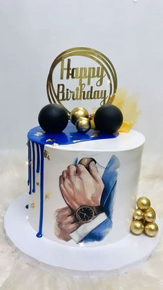 a birthday cake decorated with an image of a man's hand and gold balls