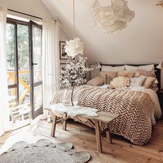 a bed sitting in a bedroom next to a large window with white flowers on it