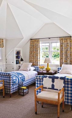 two beds in a bedroom with blue and white checkered covers on the bedding