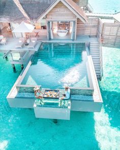 an aerial view of a house with a pool in the middle and two people sitting on chairs