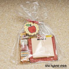 an apple themed gift bag is wrapped in plastic