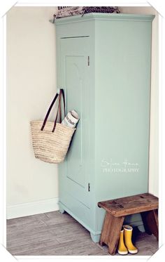 a wooden bench sitting next to a blue cabinet with a basket on top of it