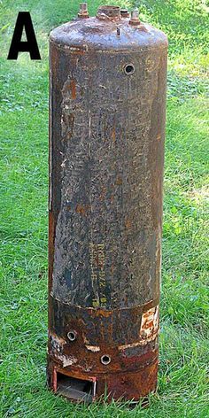 an old rusted water tank sitting in the middle of some green grass with words above it