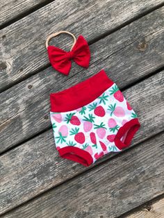 Strawberry themed bummie shorts. Made with soft cotton spandex knit with red and pink strawberries. Red waist and cuffs. Matching red bow on nylon headband. Bummies are made to be a little smaller than regular shorts and fit snug. If you don't want them snug order a size up. Matching white bodysuit with ONE in red. Playful Red Shorts For Spring, Playful Red Cotton Shorts, Red Shorts For Summer Playtime, Cute Short Red Bottoms, Cute Strawberry Print Bottoms For Spring, Pink Strawberry Print Bottoms For Summer, Fitted Pink Bottoms With Strawberry Print, Pink Fitted Bottoms With Strawberry Print, Cute Red Shorts For Spring