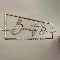 the logo for beauty bar is gold and black