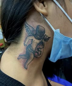 a woman with a tattoo on her neck and behind her ear is wearing a face mask