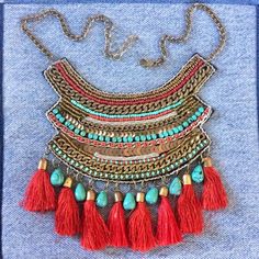 Gorgeous tassel necklace. Well made bronze tone chain and colorful glass beads (faux turquoise and faux coral) tribal bib necklace. Red tassels. Velvet backing. Necklace is adjustable from approx 12 to 14 1/2 inches. Condition is very good vintage. As found. I leave decision of cleaning up to buyer. Bohemian Turquoise Bib Necklace With Colorful Beads, Red Bohemian Beaded Fringe Jewelry, Red Bohemian Jewelry With Beaded Fringe, Bohemian Turquoise Necklaces With Tassels, Bohemian Metal Beaded Dangle Necklaces, Red Bohemian Bib Necklace For Festivals, Turquoise Tassel Necklaces For Festivals, Bohemian Beaded Tassel Necklace For Festivals, Bohemian Beaded Dangle Tassel Necklace