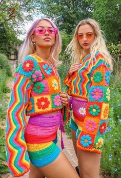 two women in colorful crochet outfits posing for the camera