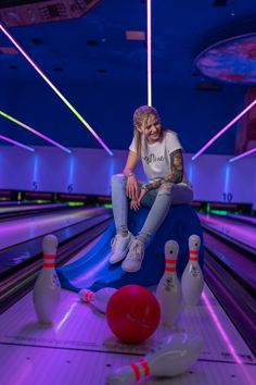 a woman sitting on top of a bowling ball