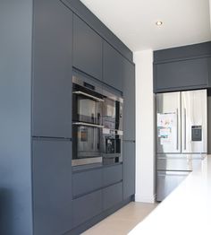 a kitchen with gray cabinets and stainless steel appliances