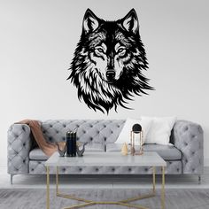 a living room with a couch, coffee table and wall decal that has a wolf's head on it