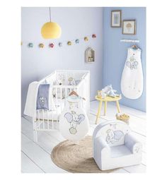 a baby's room with blue walls, white furniture and accessories on the floor