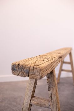 a wooden bench sitting on top of a carpeted floor next to a white wall