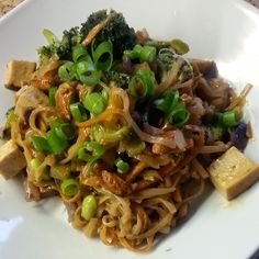 a white plate topped with noodles and vegetables