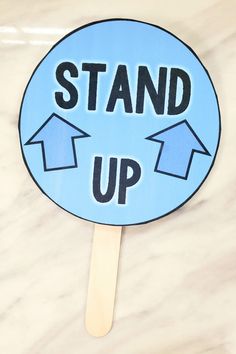 a stick with the words stand up on it and arrows pointing in opposite directions to each other