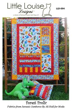 a stuffed animal sitting on top of a pillow next to a quilted wall hanging