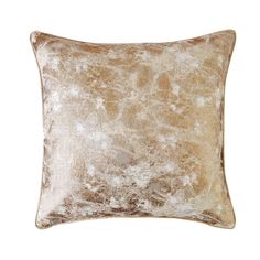 a gold velvet pillow with white and brown spots on the front, against a white background