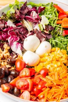 a bowl filled with different types of salads and vegetables on top of each other