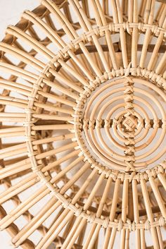 a close up of a wicker basket on a white wall with an intricate circular design