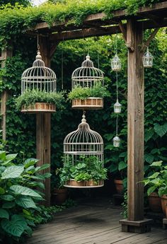 three bird cages with plants in them hanging from the side of a pergolated area