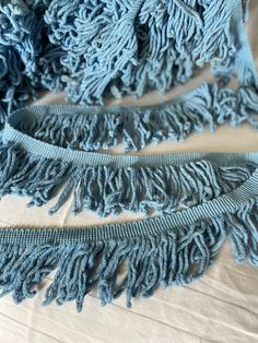 a blue scarf with fringes laying on top of it