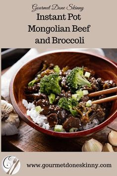 a bowl filled with beef and broccoli on top of rice next to garlic