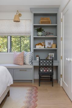 a bedroom with a window seat and built in bookshelf next to the bed