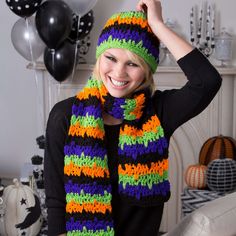 a woman wearing a multicolored crocheted scarf and hat