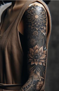 a woman's arm with flowers and leaves tattooed on the back of her body