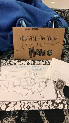 a sign that says you are on your home next to a blue blanket and some papers