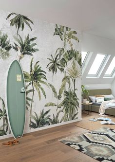 a surfboard leaning against a wall with palm trees on it in a living room