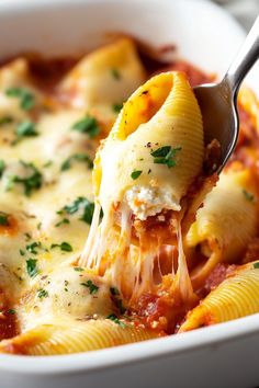 a spoon full of lasagna sauce being lifted from a casserole dish