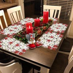 a christmas table setting with candles and decorations