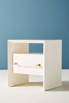 a white table with two drawers on the top and one drawer open to reveal something