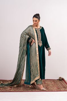 Experience the luxurious feel of royalty with our Green Velvet Shalwar Kameez. This beautiful piece features intricate embroidery on a soft green velvet shirt, with hand embroidered details on the neck and sleeves. The fully sequined georgette chiffon dupatta adds a touch of sparkle, while the 3.5 meter shawl style design adds elegance. Complete the look with the jamawar ajar pant for a traditional and sophisticated outfit. 3-Piece Suit Green Velvet Dupatta Set, Festive Green Velvet Set, Designer Velvet Salwar Kameez For Eid, Green Velvet Anarkali Traditional Wear, Green Velvet Anarkali Set, Elegant Velvet Anarkali Set With Resham Embroidery, Green Velvet Dupatta With Resham Embroidery, Elegant Velvet Embroidered Anarkali Set, Green Velvet Sets For Festivals