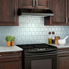 a black stove top oven sitting inside of a kitchen next to wooden cabinets and white counter tops