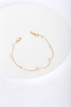 Lulus Exclusive! No matter the day or place, look your absolute best with the Lulus Keep it Stunning 14KT Gold and Pearl Bracelet! This stunning bracelet features a shiny 14KT gold plated chain with circular freshwater pearl beads. Pair with anything from a casual tee to a LBD! Lobster clasp closure. Bracelet measures 8" long. 14KT gold plated brass and freshwater pearl. Imported. Lulus | Keep it Stunning 14KT Gold and Pearl Bracelet. Dainty Chain Bracelets For Wedding, Gold Bracelets With Pearl Chain For Formal Occasions, Gold Bracelet With Pearl Chain For Formal Occasions, Formal Gold Bracelets With Pearl Chain, Minimalist Gold Metal Pearl Bracelet, Dainty Gold Bracelets With Pearl Chain, Dainty Metal Beaded Bracelets, Gold Pearl Bracelet With Adjustable Chain, Dainty Pearl Chain Bracelets For Party