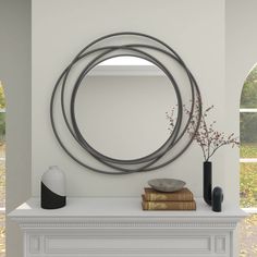 a white mantle with a mirror and vases on it next to a fire place