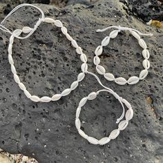 These cute chokers are perfect for that Hawaiian beachy surfer girl look. Cowrie shells are hand strung on cord to create these fun to wear pieces. Fastens behind neck with adjustable cord. One size fits most. Shell portion measures approx 12". (not including adjustable cord). 3 Piece Set includes Choker (measures approx. 15"), Bracelet (measures approx 8") and Anklet (measures approx 10") in White color. Adjustable cord will allow them all to be made larger. One size fits most. Adjustable, one Shell Choker, Cowrie Shells, Cowrie Shell, Surfer Girl, Choose Colors, Anklets, White Color, 3 Piece, Choker Necklace