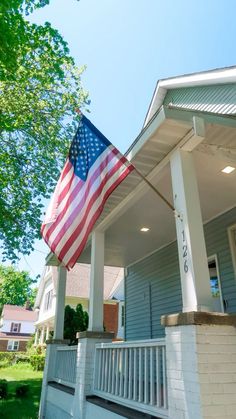 an american flag on the front porch of a house